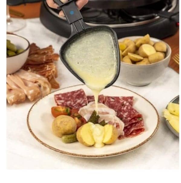 Appareil à raclette noir avec plaque grill et crêpière, 8 poêlons, avec aliments en cuisson. — vue 3