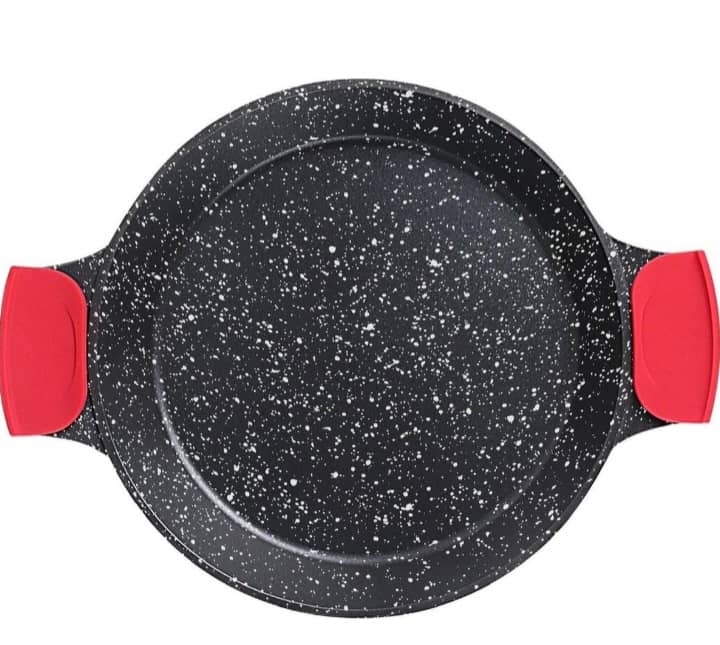 Une poêle à paella noire remplie de paella aux fruits de mer sur une table en bois rustique. — vue 2
